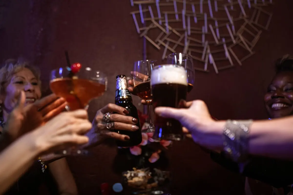 Friends around a table in a bar, glasses raised